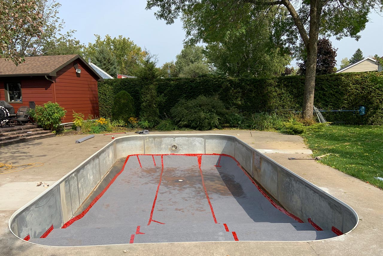 Pose géotextile tapis de protection haute densité en fond de piscine sur toute la surface